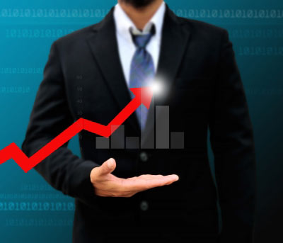 Business Man in suit holding a graph with red arrow pointing towards growth