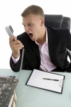 Man shouting at desk phone
