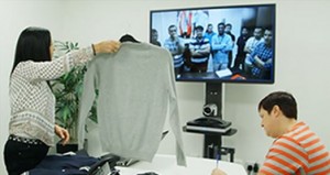 SRG holding textiles up to Polycom Video Conferencing System