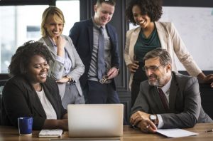 5 people team working around a laptop